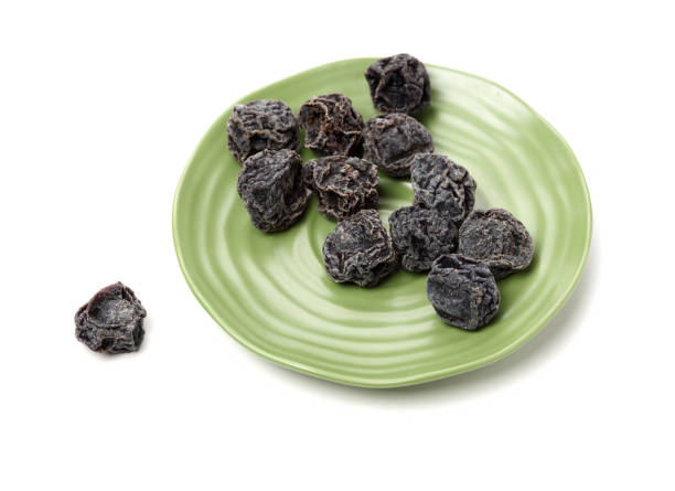 istock Dried black plums isolated on white background 1134153045