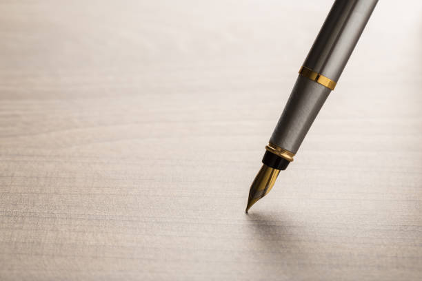 istock fountain pen on wooden table 1134159035