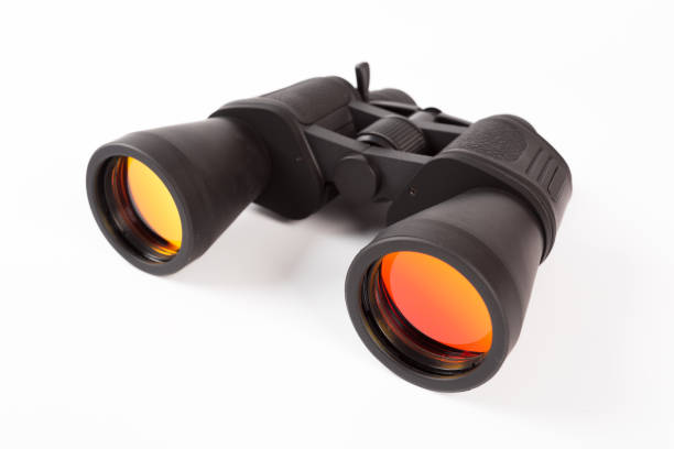 istock Black binoculars with orange lens isolated on white background 1134159057