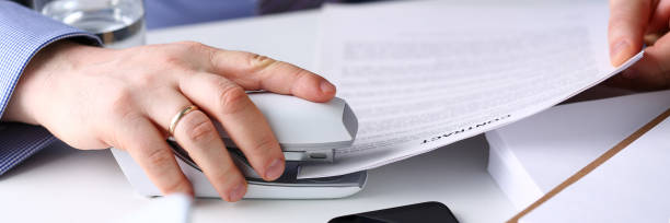 istock Male clerk arm pin together some papers with stapler 1134161004