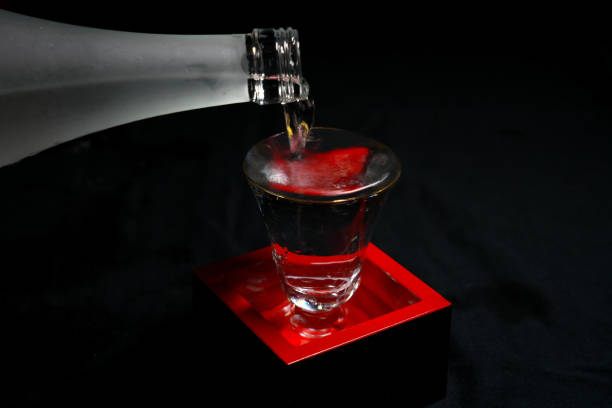 istock Pouring sake into a red lacquering inside a wooden container for drinking or measuring sake 1134167518