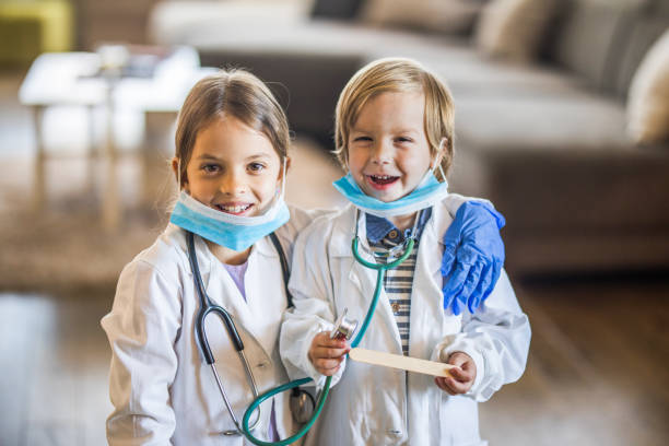 istock Happy little kids having fun while pretending to be doctors at home. 1134174262