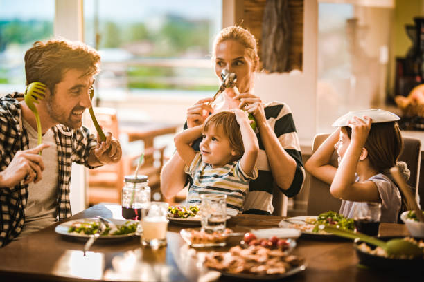 istock Playful family having fun with kitchen utensils during lunch time in dining room. 1134175478