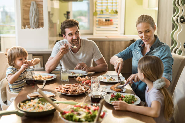 istock Young happy family communicating while enjoying in their lunch time at dining table. 1134177434