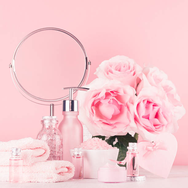 istock Romantic bathroom interior in pastel pink, silver color - flowers, round mirror, bath accessories, cosmetic products - cream, salt, rose oil, soap on white wood table. 1134178334