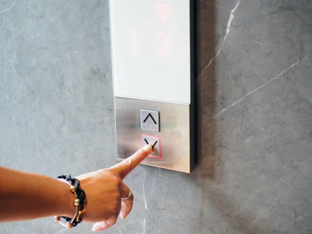 istock Woman hand press down arrow symbol  button outside elevator, selected to go downstairs. 1134178878