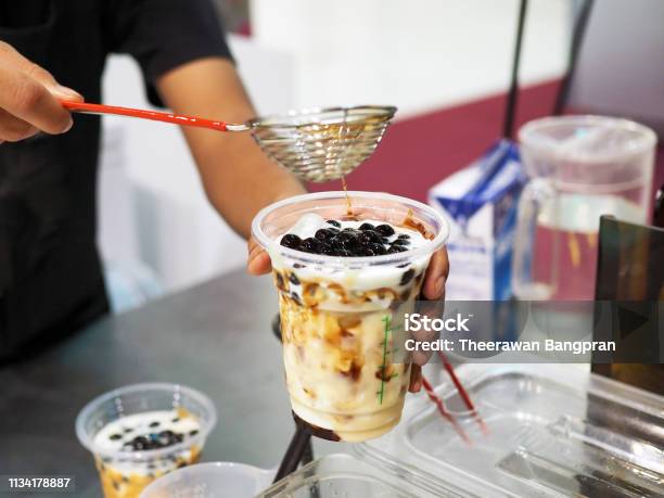 Photo libre de droit de Verser La Perle De Sucre Brun Sur Le Verre De Lait Frais Glacé Boisson De Mode De Vie banque d'images et plus d'images libres de droit de Thé au lait aux perles de tapioca