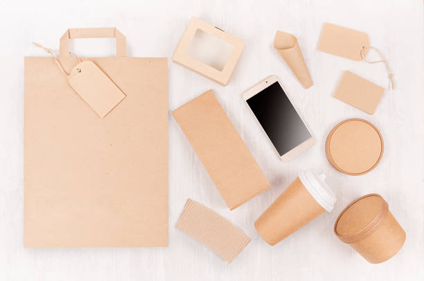 istock Food branding identity mockup in light modern style - blank screen phone, bag, cup, packet, box, label, card, container of brown paper on white wood board. 1134179496