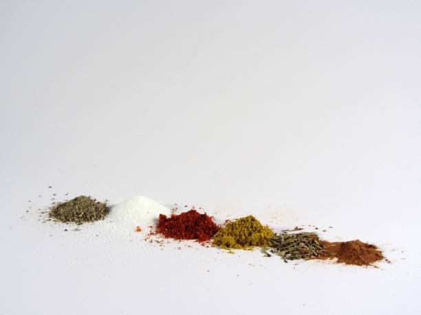 Various ground spices Various ground spices, including black pepper, paprika, salt, nutmeg, cinnamon, curry and origano, arranged in a row on white. majoran stock pictures, royalty-free photos & images