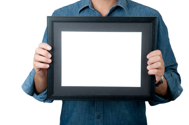 istock Man with blue jean shirt hold black picture frame 1134182324