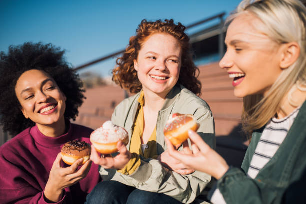 istock Group of women eating donuts 1134185245