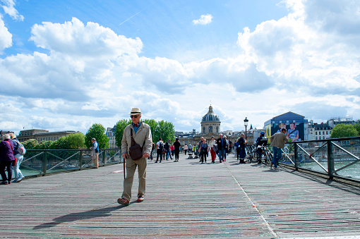 Paris, France, April 25, 2018; People walking on Pont des Arts bridge over the River Seine of Paris on a sunny day