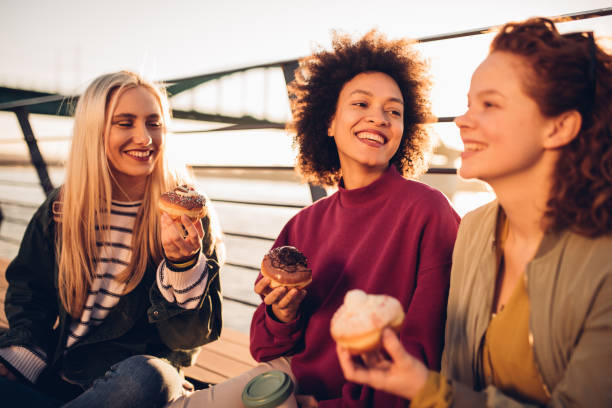 istock Smiling girls eating donuts 1134186691