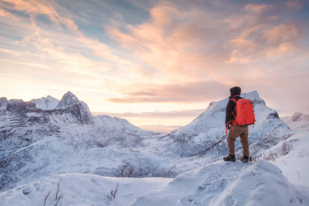 istock Tourist man climbs on top snowy mountain 1134187420