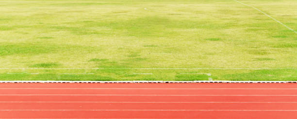 istock Natural green grass field and orange Running Track background. 1134187824