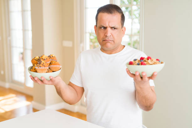 istock Middle age senior man choosing between muffins or healthy cereals 1134188388