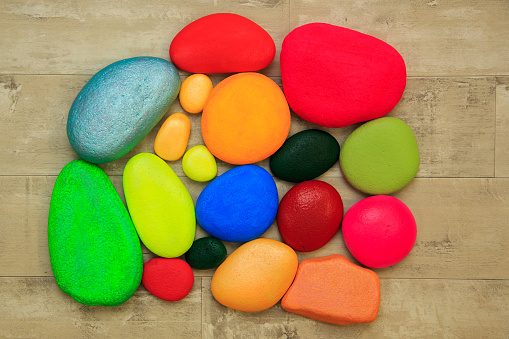 Colourful painted stones on a shabby board background
