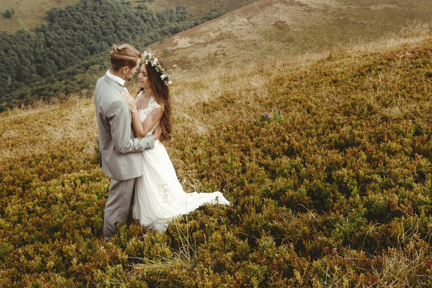istock happy gorgeous bride and groom hugging in sun light, boho wedding couple, luxury ceremony at mountains with amazing view, space for text 1134190840