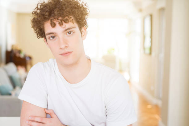 istock Young handsome man wearing white t-shirt Relaxed with serious expression on face. Simple and natural with crossed arms 1134192155