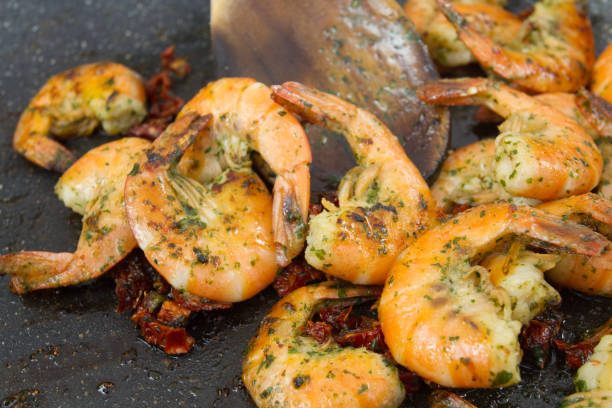 Shrimp with garlic and parsley cooking in a pan of shrimp cooked with garlic and parsley grillade stock pictures, royalty-free photos & images