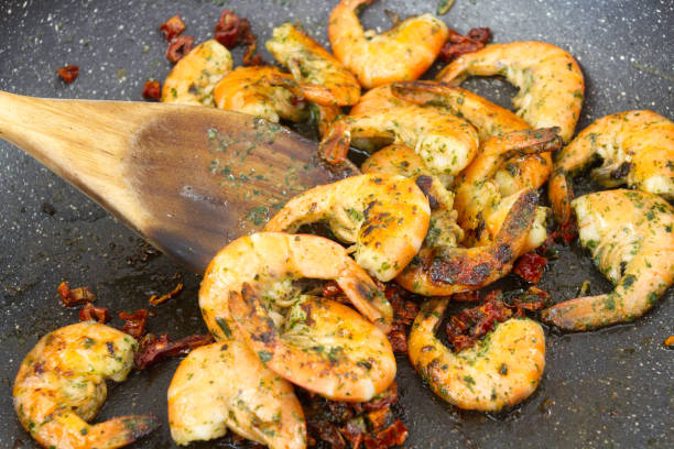 Shrimp with garlic and parsley cooking in a pan of shrimp cooked with garlic and parsley grillade stock pictures, royalty-free photos & images