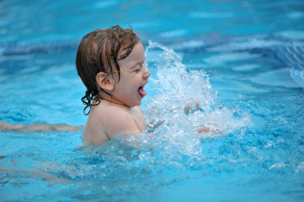 istock Baby boy  having fun in a swimming pool with his mom 1134193575