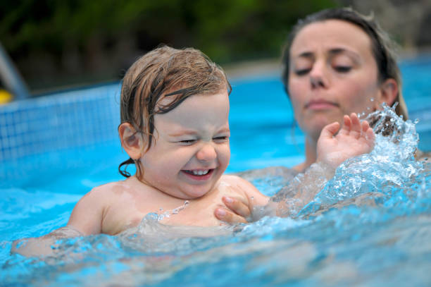 istock Baby boy  having fun in a swimming pool with his mom 1134193583