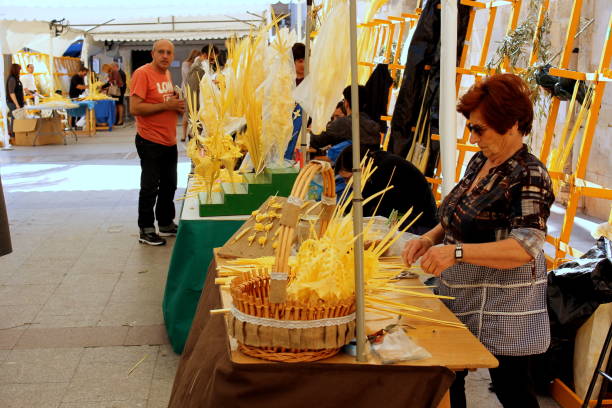 vendedoras de palmeras blancas en varios puestos callejeros durante las vacaciones de pascua en la ciudad de elche, españa - elche españa fotografías e imágenes de stock