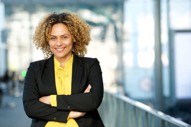 happy businesswoman posing with arms crossed stock photo