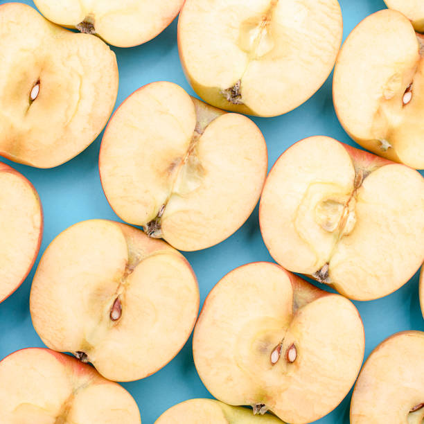 istock Background of cut in half apples on blue background 1134195401