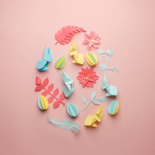 istock Easter egg shape made of various Easter origami paper craft decorative elements on pink background. Minimal spring concept. Flat lay. 1134195654