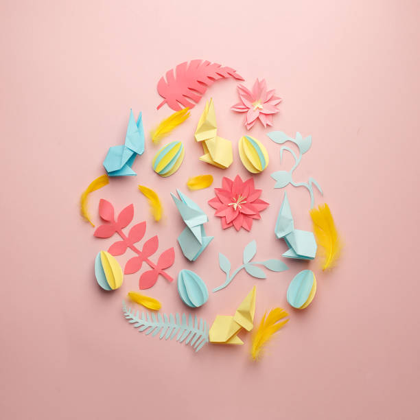 istock Easter egg shape made of various Easter origami paper craft decorative elements on pink background. Minimal spring concept. Flat lay. 1134195657