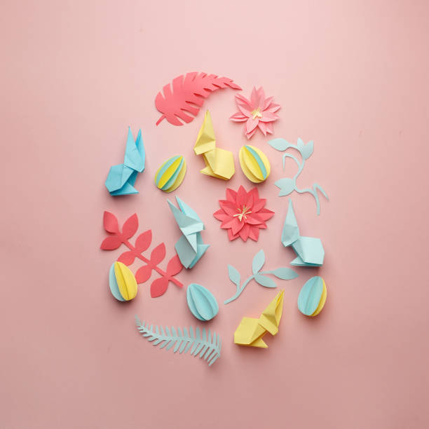 istock Easter egg shape made of various Easter origami paper craft decorative elements on pink background. Minimal spring concept. Flat lay. 1134195660