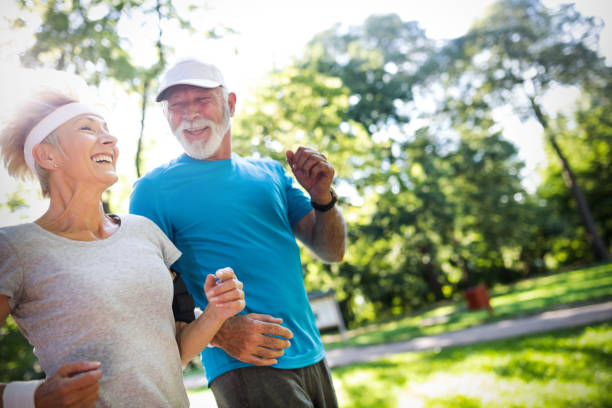 leitende frau und mann laufen bei fitnessübungen - action senior adult lifestyles couple stock-fotos und bilder