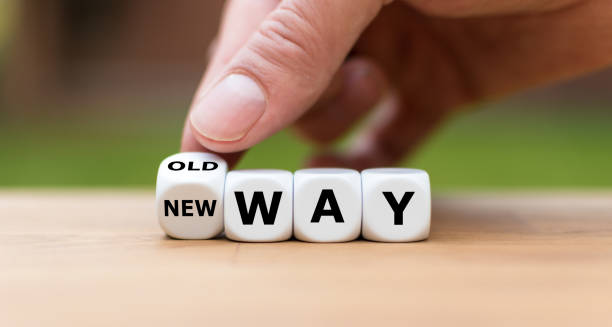 Hand is turning a dice and changes the expression "old way" to "new way" stock photo