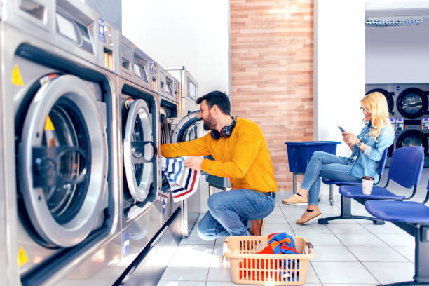 el hombre joven lavando su ropa - all laundry detergent audio fotografías e imágenes de stock