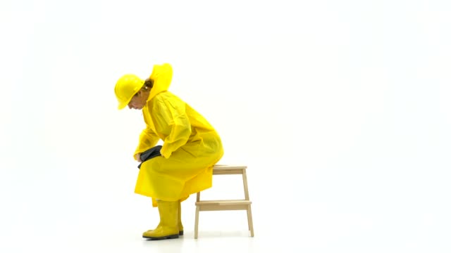 Middle adult woman in yellow raincoat and rain boots