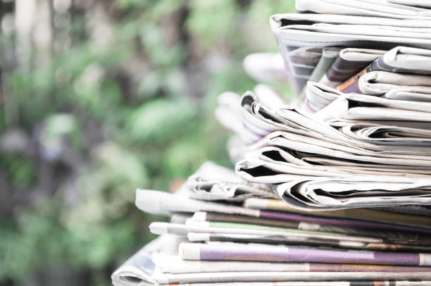 istock Newspapers folded and stacked on the table with garden. Closeup newspaper and selective focus image.Time to read concept. 1134208040