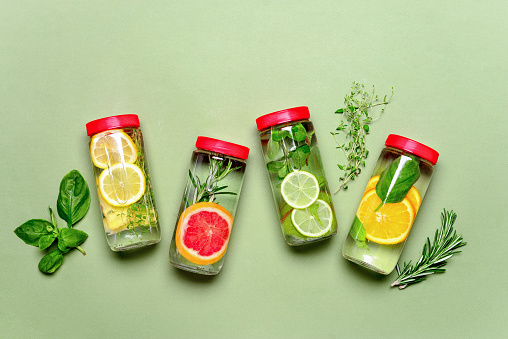 Fruits and culinary herbs bottled infused water, flat lay composition