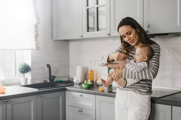 istock Young mother feeding from spoon her baby in the kitchen 1134212090