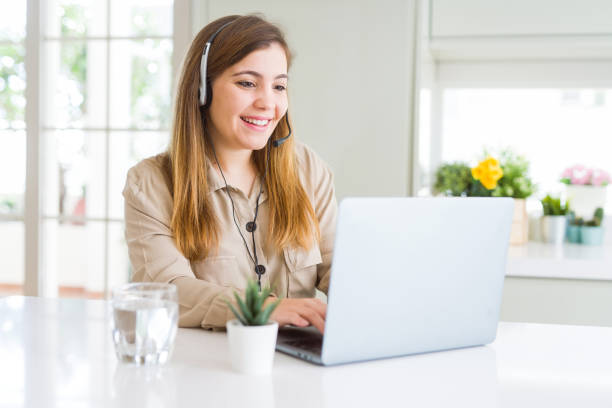 schöne junge bedienfrau, die mit laptop arbeitet und kopfsitz mit einem glücklichen gesicht steht und lächelt mit einem selbstbewussten lächeln, das zähne zeigt - toothy smile relaxation white healthcare and medicine stock-fotos und bilder