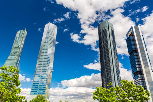 A wide-angle and low-angle view of a modern skyscraper in Madrid emphasizes its impressive height and sleek architectural lines