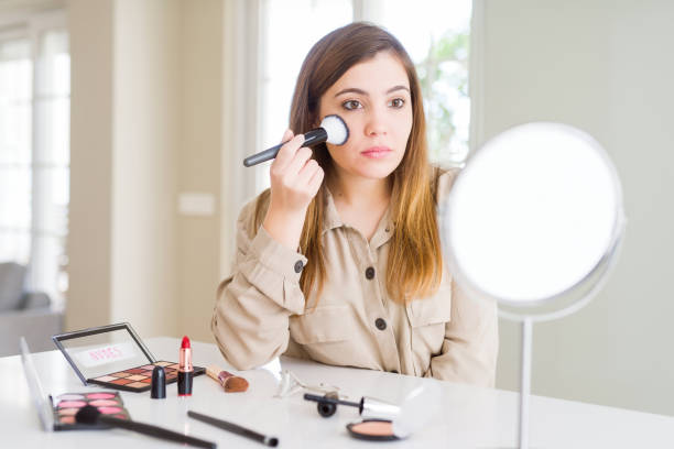 istock Beautiful young woman using make up cosmetics applying color using brush with a confident expression on smart face thinking serious 1134221637
