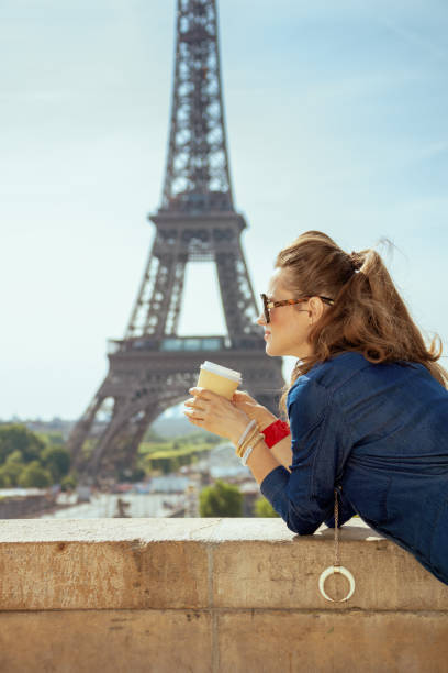 istock traveller woman against Eiffel tower drinking coffee 1134221898