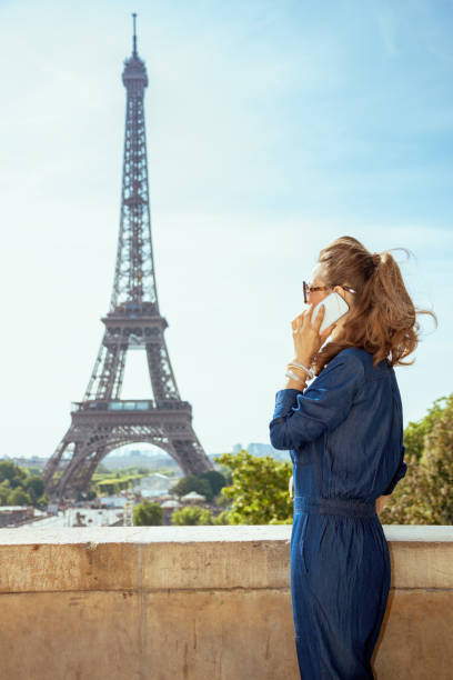 istock tourist woman against Eiffel tower talking on smartphone 1134222032