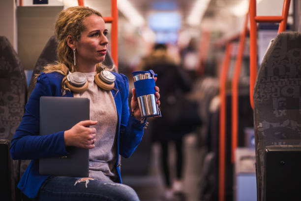 Busy businesswoman drinking coffee in train.