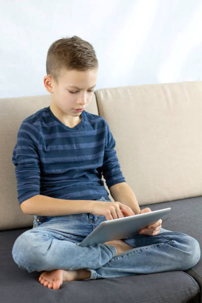 istock Teen boy using tablet. Child boy playing game or checking social media on tablet during recreation time at home. Internet online education, technology, children's security, internet safety concept 1134225749