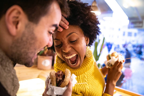 Friends playing while eating a burger Friends playing while eating a burger veggie burger photos stock pictures, royalty-free photos & images