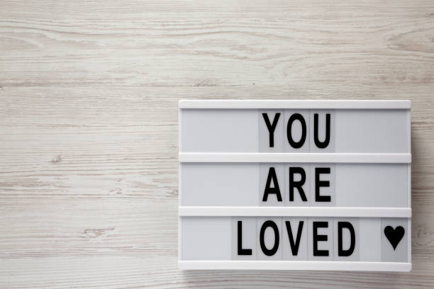 istock 'You are loved' words on lightbox on a white wooden surface, top view. Flat lay, overhead, from above. Copy space. 1134227651