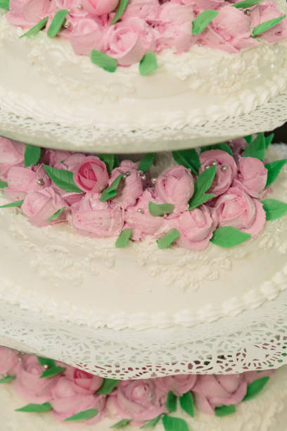 White rose wedding cake decoration on unfocused white background. Full frame, selective focus, extreme close-up.